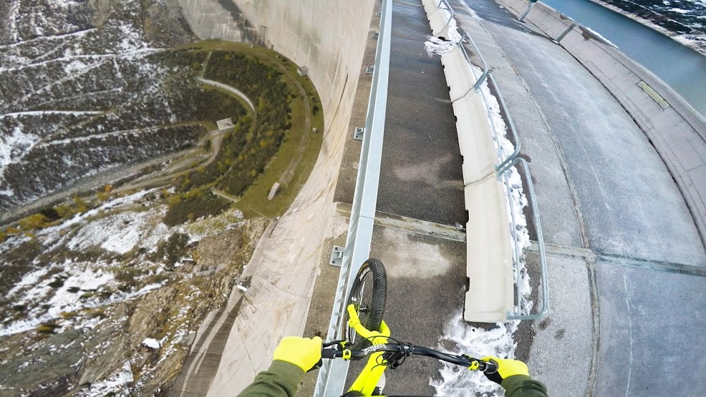 Ez a srác egy 200 méter magas gát korlátján egyensúlyozik biciklivel