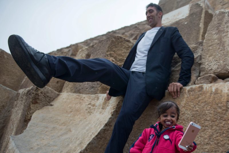 A török Sultan Kosen, a világ legmagasabb férfija és az indiai Dzsjoti Amge, a világ legalacsonyabb nõje a gízai piramisoknál, Egyiptombnan 2018. január 26-án. A 243 centiméter magas Kosen és a 62,8 centiméteres Amge az Egyiptomba irányuló turizmus fellendítésének érdekében tartózkodik az országban. (MTI/EPA/Mohamed Hoszam)